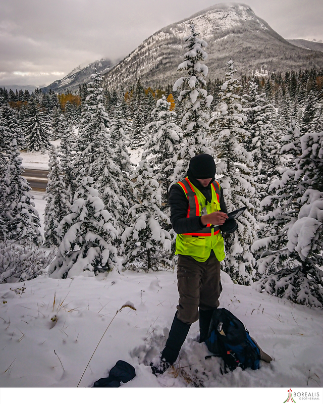A Borealis Geothermal team member with a neon worker's vest conducting GIS Services and Surveying