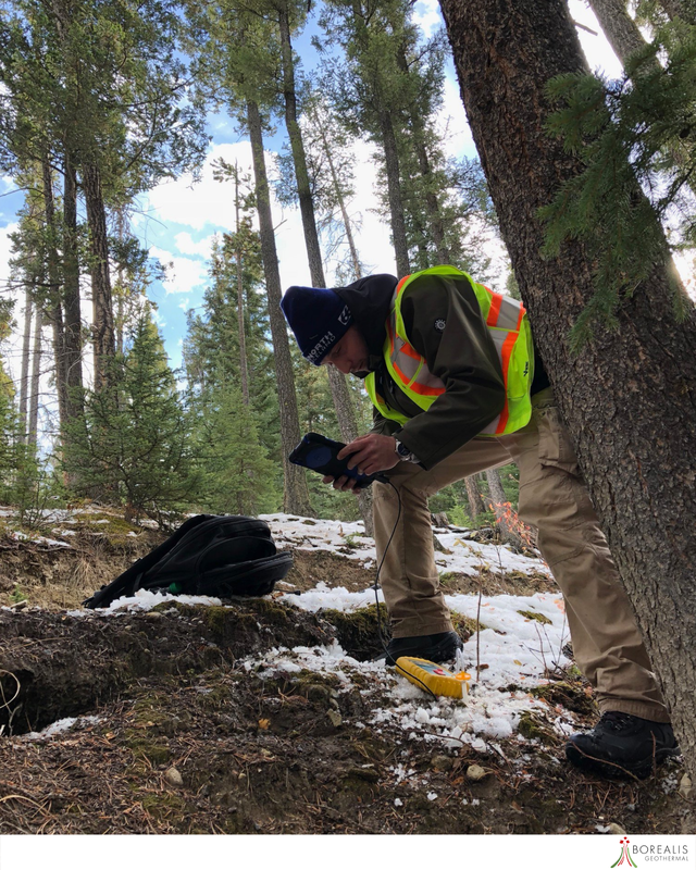 A Borealis Geothermal team member with a neon worker's vest tests for Soil Gas Surveys
